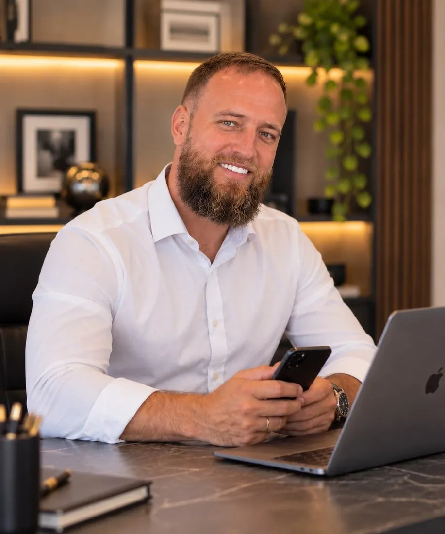 Patric Duarte à mesa de trabalho, com o celular nas mãos